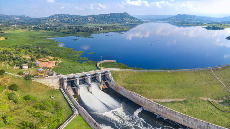 Water dam surrounded by green fields and lake