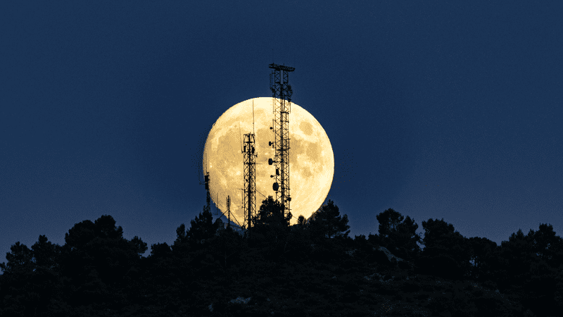 Dark sky with cityscape and full moon